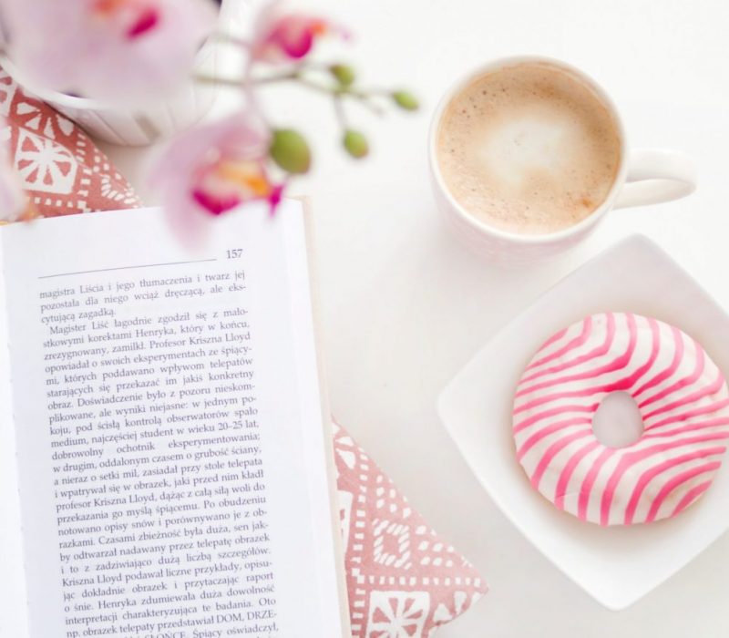 a-book-cup-of-coffee-and-flavoured-donut-on-square-white-696179